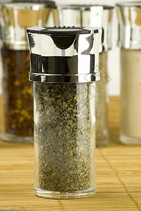 新鲜的丰富多彩调味料在一个玻璃罐子里用木垫上不同的香料背景图片