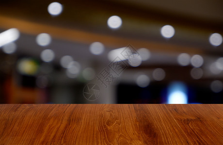 餐厅购物商场内地的空黑木桌面对抽象模糊的背景可以用来展示或装配产品图象片为了咖啡木制的图片