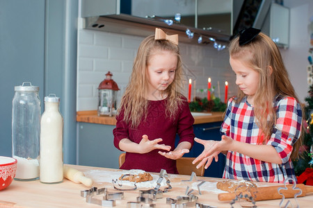 快乐的小女孩在家中厨房为圣诞节做姜饼干令人敬佩的快乐小女孩在圣诞前夕做姜饼干笑声在圣诞节晚宴上做面包饼干糖果自制厨师图片