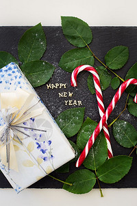 问候云杉新年在黑板上登记盛满一份好礼物和红糖果在黑板上写着新年的礼物和红糖果色的图片