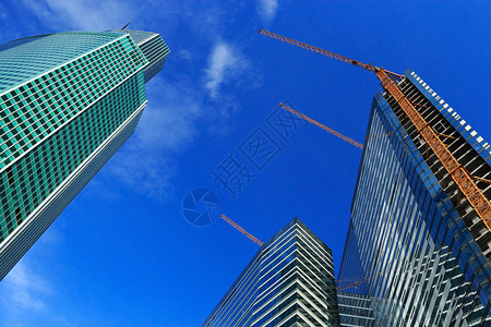 视窗高楼建筑未完成有起重机对着蓝天商业城市的图片