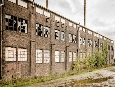 旧工厂和陈墙壁风化窗户破碎坏肮脏的空图片