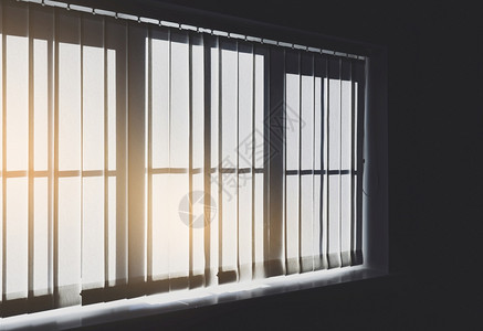 在反向过滤器中窗帘的阴影和晨光照亮在微小线和光的窗口下通过威尼斯百叶窗罩闪耀滚轴射线复古的图片