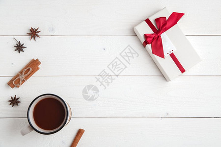 最佳可星新年背景肉桂火化恒星fir树枝aCup热巧克力和一个盒装礼物的子白色木制背景图片