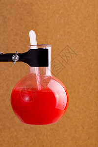 体液关心红色的木背景中红色液体的试验瓶图片