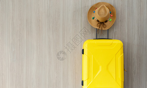 乘坐黄色彩旅行车身和棕草干女牛仔帽在棕色木墙背景上挂彩色的花旗并复制空间旅行和暑假概念帽子女孩流苏图片