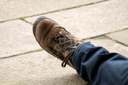 步行棕色的西班牙修复朝圣腿在铺路石堆上用徒步靴子修补朝圣者腿图片