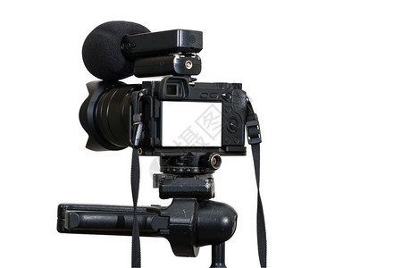 在三脚架上用麦克风记录白色背景的摄影或像师照相机现场流动设备概念包括剪切路径等专业数字式无镜相机在有麦克风记录的白色背景上制摄像图片