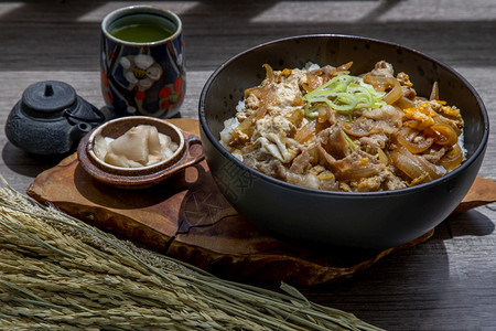 米可口日本猪肉饭碗配鸡蛋和洋葱Donburi在木桌日本菜风格上配有姜咸菜和绿茶麻布图片