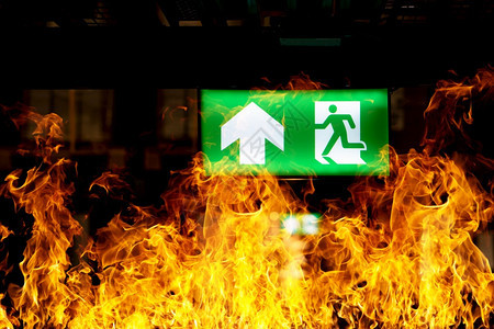 部件逃脱仓库天花板上挂着绿色逃生标志火灾训练的概念和疏散准备象征背景图片