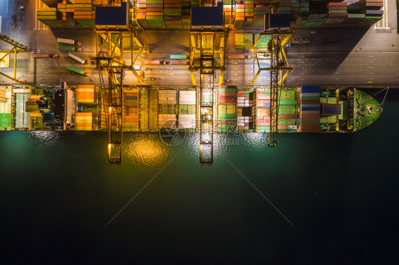 加载泰国大型货集装箱船乘大型货集装箱船在泰国夜间照明时从无人驾驶飞机摄像头对望上方的无人驾驶摄影机夜晚建造图片