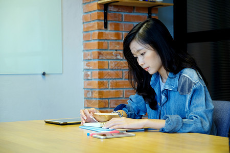 亚洲女大学生在黄色书桌上认真学习的照片图片