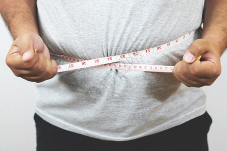 肥胖男子想通过每天的锻炼来减肥控制食物饮失去胶带图片