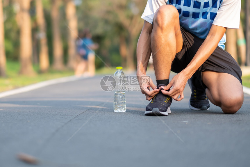 青年运动员男子在公园露户外运动鞋上绑着男跑者准备在像亚人Fitness那样的外面路上慢跑早在健康和体育概念中步行和徒运动马拉松外图片