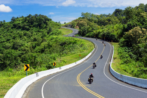 三号公路或山峰上空美丽的天路旅游者们乘摩托车在泰国山顶的南省上游荡的坡泰国南省绿色漫游沥青图片