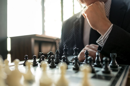 玩领导者拥有象棋盘游戏策略和竞争的商人业图片