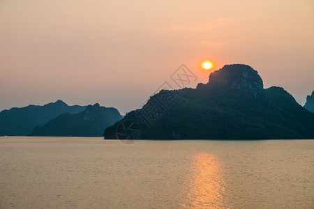日落在越南哈隆湾的山峰和海面上下龙橙黄昏图片
