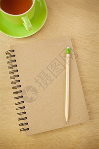棕色的覆盖绿在木本背景上回收笔记本和木铅图片