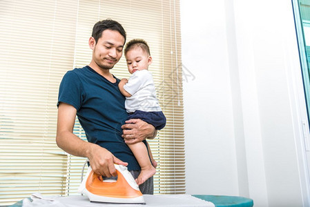 工作器具单身父亲带着儿子时烫衣服人和生活方式的概念家庭图片