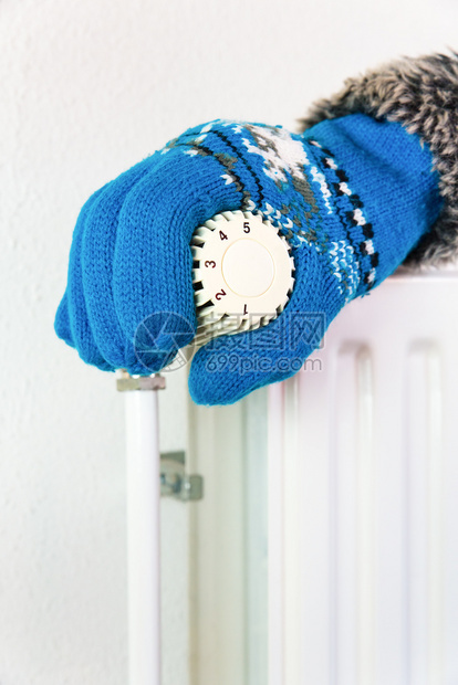 冬季寒冷时戴手套的在暖气阀门中转动水垂直的自在图片
