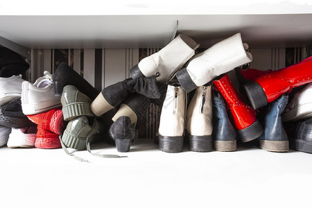 女士为了在鞋架中收集不同的旧鞋用于存放凌乱和需要整理在室内设计中带架子的衣柜有复制空间垃圾摇滚图片