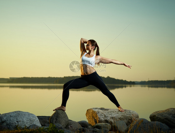 女士美丽的年轻青在清晨练瑜伽平静的海在背景上女日出图片