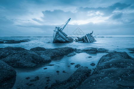 日落背景的古老海上沉船事故放弃古老的运输图片