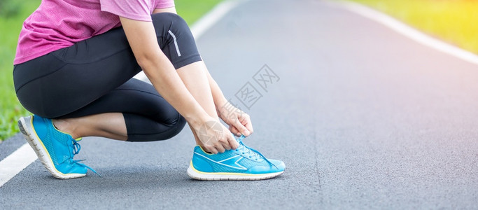 重量自然运动鞋在公园户外露天运动带领鞋的年轻成女子运动员选手妇女准备在上午锻炼健康的生活方式和健身概念中跑步和慢图片