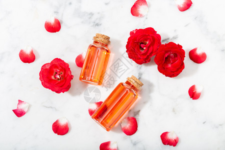 草本质玻璃瓶和小红玫瑰中的香水配有花瓣按摩芳香疗法和有机化妆品概念花的图片
