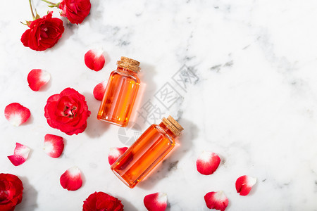 自然植物群香气玻璃瓶和小红玫瑰中的香水配有花瓣按摩芳香疗法和有机化妆品概念图片