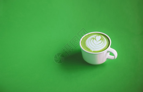 可口咖啡为了绿色茶叶概念热相配绿色茶奶霜上面有艺术顶白色杯子绿背景的白杯用于横幅设计复制空间图图片