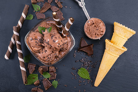 把巧克力冰淇淋放在玻璃碗里配有面包棒甜瓜和巧克力在黑板上集中关注碗配有勺子巧克力冰淇淋食物清爽胡扯图片