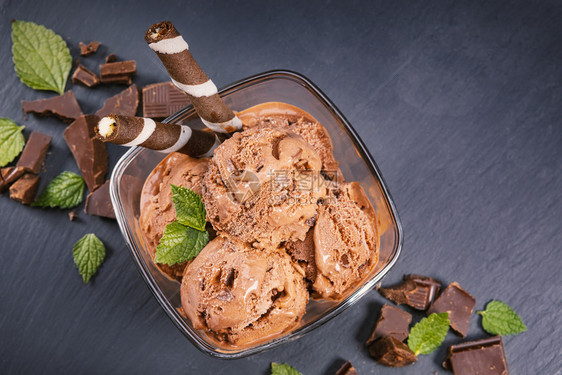 茶点冷冻小吃把巧克力冰淇淋放在玻璃碗里配有面包棒甜瓜和巧克力在黑板上集中关注碗配有勺子巧克力冰淇淋图片