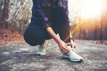 妇女系鞋带绑供运动员健身选手准备在夏季末或秋森林路上的户外慢跑健康活动搭售图片