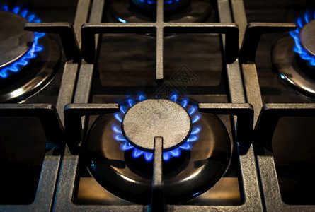 蓝色的热圆圈家用煤气炉装有燃烧的炉关闭火焰燃气炉图片