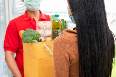 包面具来自超市的亚洲送货员身戴面罩持有一袋新鲜食品蔬菜和水果供家里顾客使用特快杂货服务和新生活方式概念服务与新生活方式白种人图片