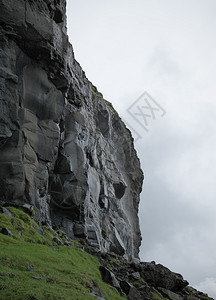 墙高的在法罗群岛瓦加尔的左侧用石头楼梯下雨后由火山起源的湿黑色岩壁垂直彩地形图像法罗群岛光荣景象法罗群岛的贺卡图案有质感的图片