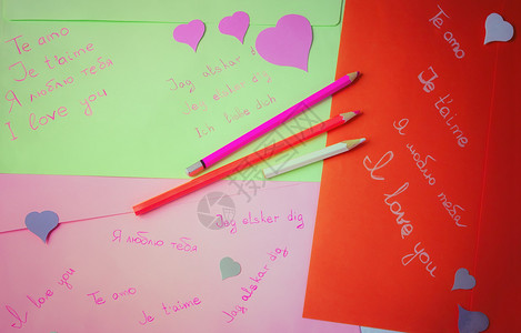西班牙语用彩色铅笔手写在不同彩色信封上以纸心写的爱宣言手情用彩色铅笔写简短的脚本图片