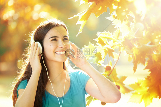 在秋天的优美节日以耳语聆听音乐节目时阳光青少年明亮的图片