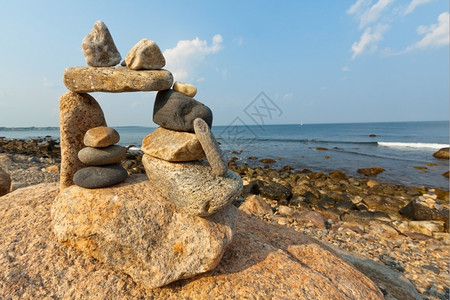 海景海报多岩石的海岸线罗得岛海滨的日落景通过象zen一样的石头结构云背景