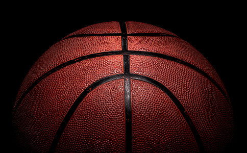 弹跳细节从上方照亮的篮球一部分在黑色背景上闪亮竞赛图片