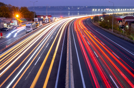 运输郊区的夜间高速公路车头灯和尾的痕迹交通繁忙的尾灯和公路上晚间汽车与铁轨交和卡泊桥的灯光天空图片