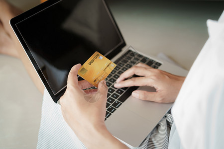 保持近身妇女正在网上与信用卡使笔记本电脑和进行在线交易的女用信卡妇一起购买钱图片