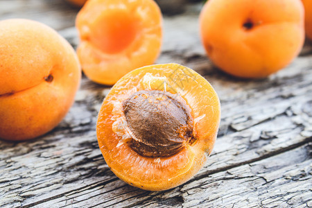 小吃复制可口黄杏仁放在木制桌子上近身的红杏子躺在木制桌上图片