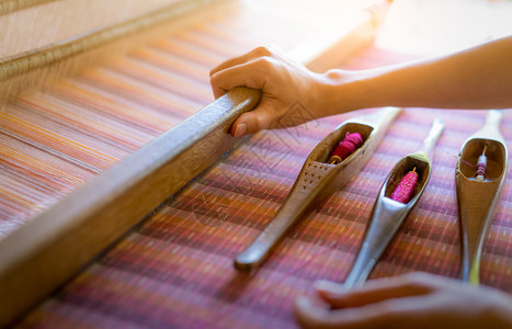 服装工业的在织机上作妇女用于编织手工物纺编使用传统手工织布机在棉线上编织泰国亚洲文化中的纺织或布料生产为了图片