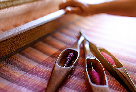 在织机上工作的妇女用于编织手工物纺编使用传统手工织布机在棉线上编织泰国亚洲文化中的纺织或布料生产纱笼细绳机器图片