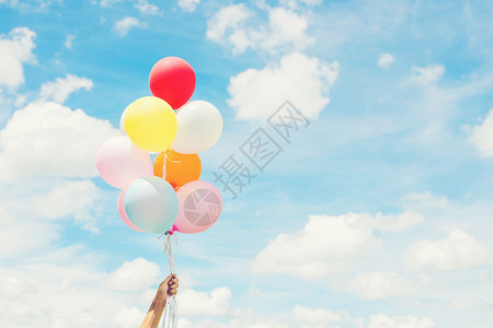 美丽的女人生活方式概念女人手握着一堆彩色气球蓝天空女人生命风格概念女人手握着一帮有色人种的气球乐趣复古图片