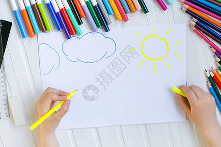 童子手用彩色铅笔涂在木制桌上一张白纸童子手用彩色铅笔画在纸上颜色婴儿白的图片