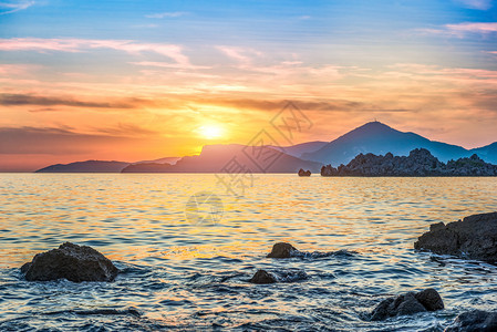 夏天水平的日落时亚得里海的大块石头和岩黑山海中块水图片
