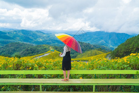 亚洲女拥有多色雨伞在花田中放松节假日旅行微笑快乐户外图片